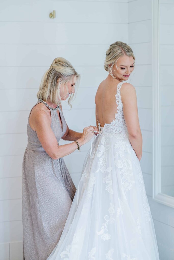 A beautiful intimate moment between the bride and her mom helping zip up her dress. photo taken by Isa Wines Photography at La Pointe Events, Somerset Wisconsin. 