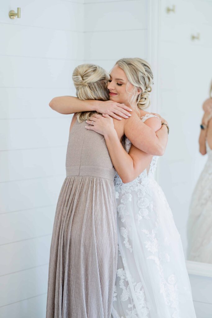 Casey hugging her mother on her wedding day. Initmate, beautiful and touching moment between them. A bridal moment of Casey on her wedding day. A beautiful intimate moment between the bride and her mom helping zip up her dress. photo taken by Isa Wines Photography at La Pointe Events, Somerset Wisconsin. 