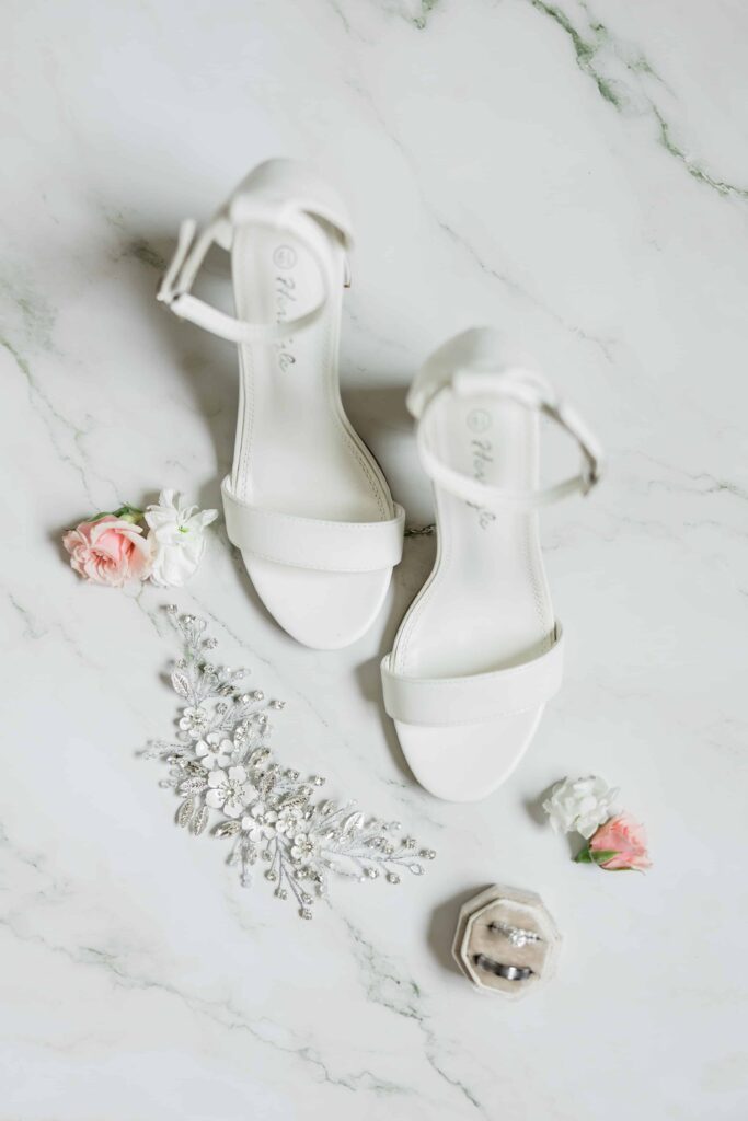 Bridal details flatly. Rings and invitations are beautifully captured in this photo. Color palette of rose, white and gray.